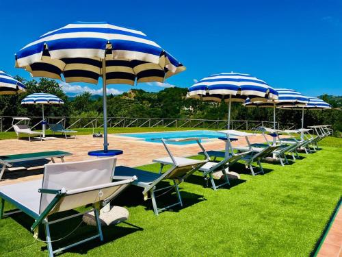 a row of chairs and umbrellas next to a pool at Affittacamere La Grotta Magica in Venagrande