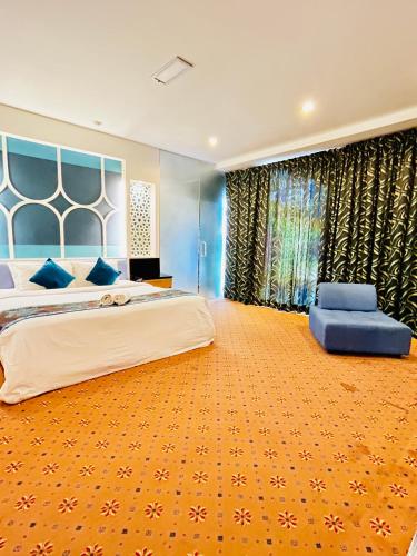a large bedroom with a large bed and a blue wall at Hotel El-Zahraa - Sungai Petani in Sungai Petani