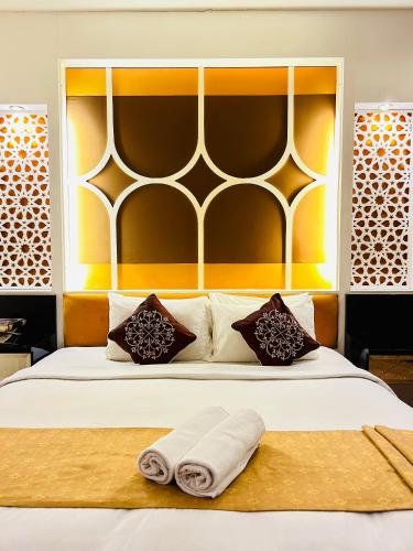a bedroom with a bed with two towels on it at Hotel El-Zahraa - Sungai Petani in Sungai Petani