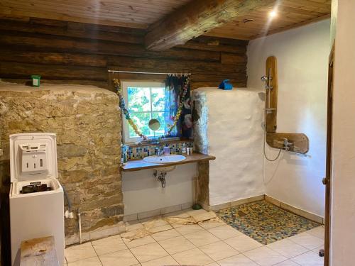 ein Badezimmer mit einem Waschbecken in einer Steinmauer in der Unterkunft Pärtli-Jaani Elukoda 