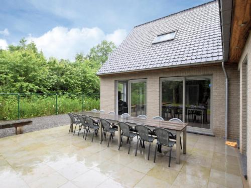a wooden table and chairs on a patio at Luxurious Home with Sauna in Somme-Leuze
