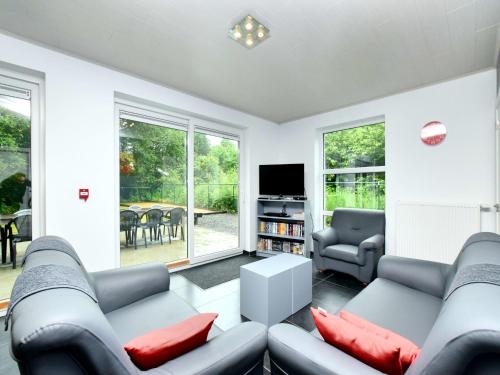 a living room with two couches and a tv at Luxurious Home with Sauna in Somme-Leuze