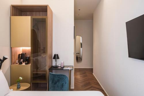 a bedroom with a bed and a desk and a tv at Palazzo Buenos Aires in Milan