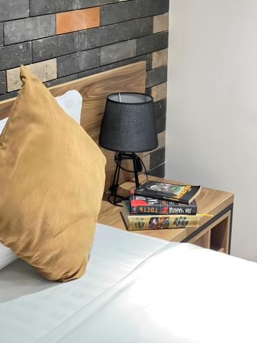 a bed with a pillow and a lamp on a table at Rooms Apart Hotel by RED in Yerevan