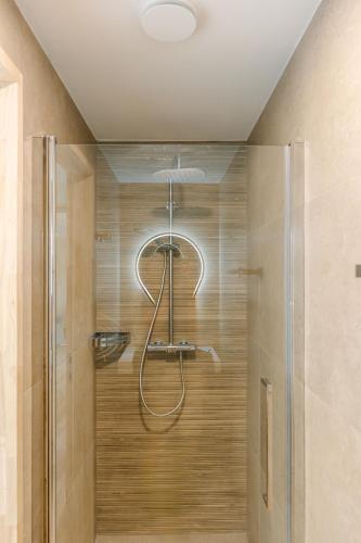 a shower with a glass door in a bathroom at La Ferme d'Auwez - Arbre de vie - Gîte 4 pers avec piscines et sauna in Ciney
