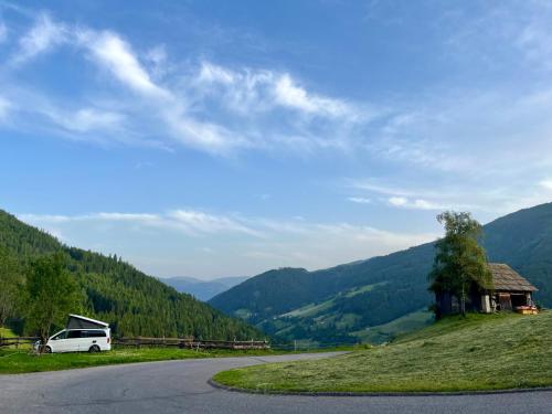 a white van parked on the side of a road at Stellplatz mit Aussicht auf Bergbauernhof in Rennweg