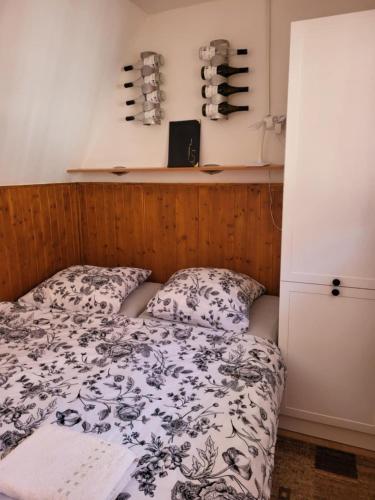 a bedroom with a bed and a shelf with wine bottles at Sklep u Veselých in Mutěnice
