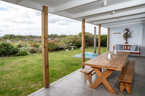 a wooden table on the patio of a house at Kelkiewyn in Yzerfontein in Yzerfontein