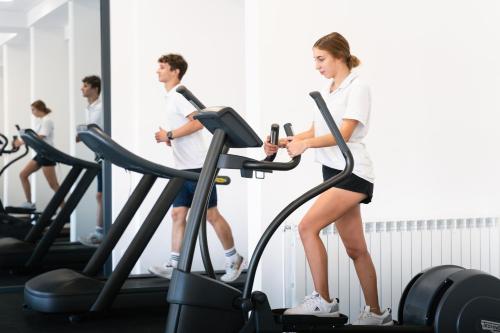 a man and a woman on a treadmill in a gym at MASLINICA Hedera Hotel in Rabac