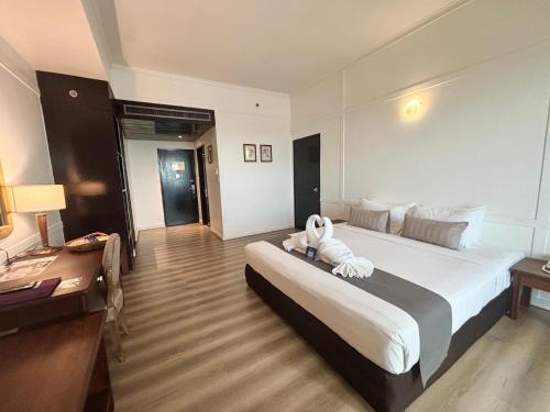a hotel room with a bed with a towel on it at Napalai Hotel in Udon Thani