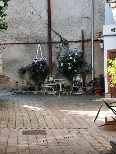 een terras met twee stoelen en een tafel met bloemen bij Oldtownvilla studio central in Sibiu
