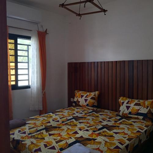 a bedroom with a bed with a quilt on it at Appartement M1,M2,M3 in Nosy Be
