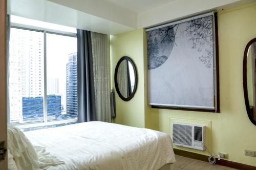 Un dormitorio con una cama y una ventana grande. en Monitor Gear Residences, en Manila