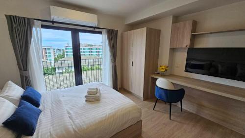 a bedroom with a bed and a large window at Cabanas Huahin by PTA in Hua Hin