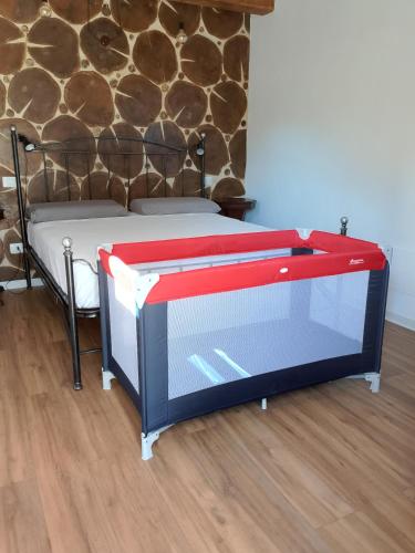 a bed with a red frame in a room at Agriturismo la casa degli amici in Cossignano