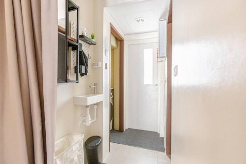 a small bathroom with a sink and a mirror at Nueng Rana 232 Corner view 1BR Duplex 3beds / 2B in Samphanthawong