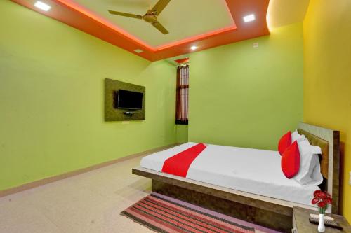 a bedroom with a bed in a room with green walls at Hotel O The Heart Residency in Rāmgarh