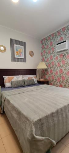 a bedroom with a large bed with floral wallpaper at Love View Condotel in Piapi
