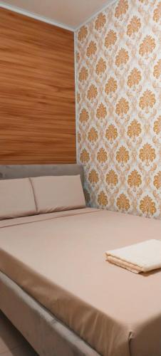 a bed in a room with a wall at Love View Condotel in Piapi