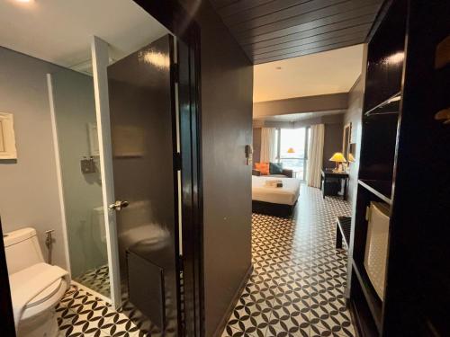 a bathroom with a toilet and a bedroom at Napalai Hotel in Udon Thani