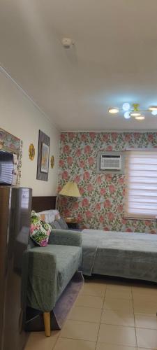 a bedroom with a bed and a couch and a window at Love View Condotel in Piapi