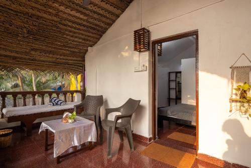 a room with a bed and a table and chairs at Forget Me Not Resort in Agonda
