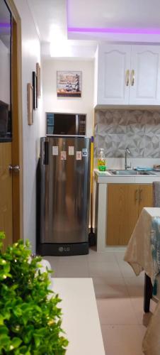 a kitchen with a stainless steel refrigerator and a sink at Love View Condotel in Piapi
