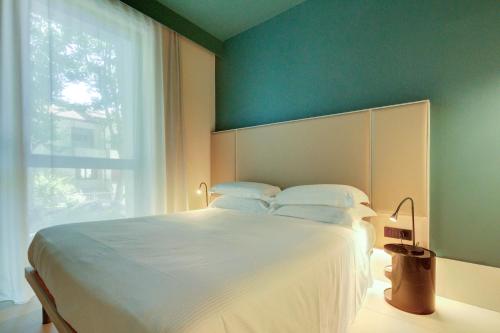 a bedroom with a large white bed and a window at Le stanze di Caterina in Cesenatico