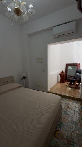 a bedroom with a bed and a chandelier at Dimora Donna Carmela in Capaci
