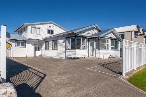 a white house with a fence in front of it at Victoria Hostel in Rotorua