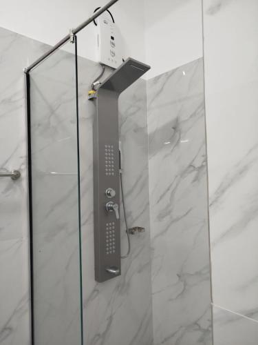 a shower with a remote control on the wall at Hotel Alaskabay Arugambay in Arugam Bay