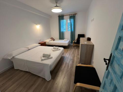 a room with two beds and a table in it at Casas de Valtravieso El Jardín in El Pozo de los Frailes