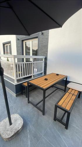 a patio with a table and a bench and an umbrella at Apartment Deluxe Livno in Livno