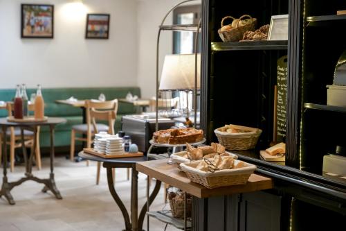a bakery with a table with bread and baskets on it at Hôtel de Biencourt in Azay-le-Rideau