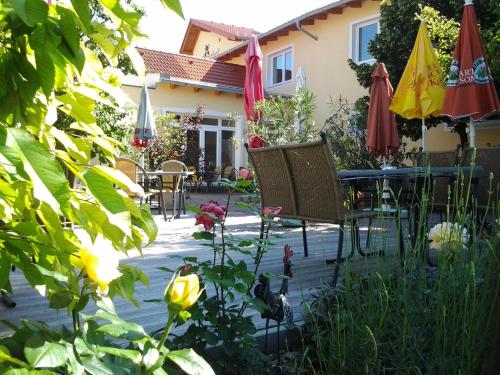 a patio with chairs and umbrellas in front of a house at Der Winzerhof in Achau