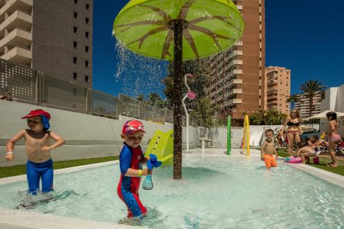 a group of children playing in a pool with an umbrella at RH Princesa Hotel & Spa 4* Sup in Benidorm