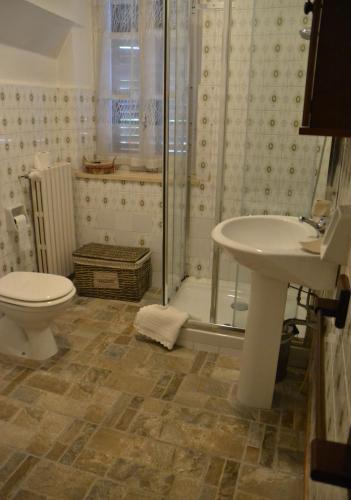a bathroom with a shower and a toilet and a sink at Casa Mortarino in Bozzole