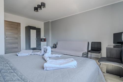 a bedroom with a large bed with towels on it at Pablo in Niechorze