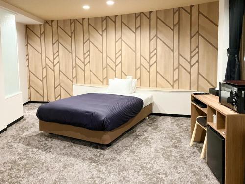 a bedroom with a bed and a television in it at Hotel LiVEMAX Naha Naminoue 1 in Naha