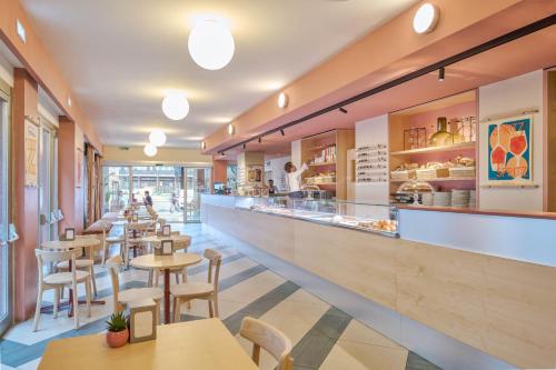a restaurant with a long counter and tables and chairs at Moderno Hotel Roma in Rome