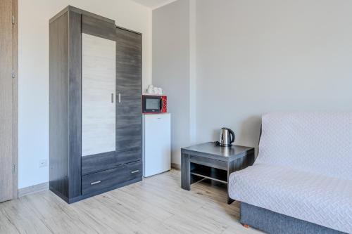 a bedroom with a bed and a table with a microwave at Pablo in Niechorze