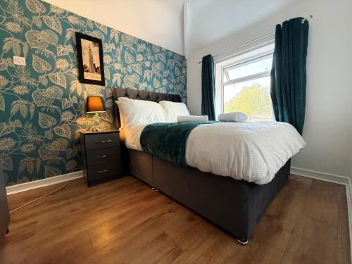 Exhallにある3 Bedroom House Near Arenaのベッドと青と緑の壁紙が貼られた窓のある寝室