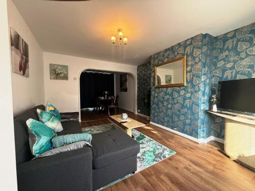 a living room with a couch and a tv at Comfy 3 Bedroom House Near CovArena & TrainStation in Exhall