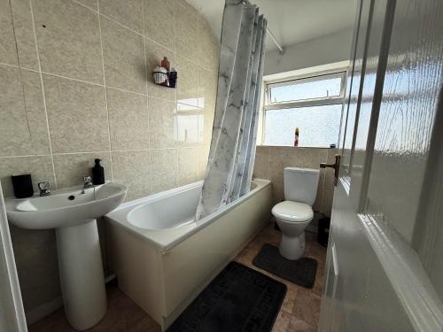 Exhallにある3 Bedroom House Near Arenaの洗面台、浴槽、トイレを備えたバスルーム