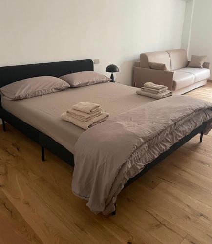 a large bed in a room with a couch at Casa Arduino in Ivrea