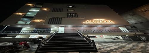 a building with a staircase in front of a parking lot at Aditi Hotel and Banquets in Karīmnagar