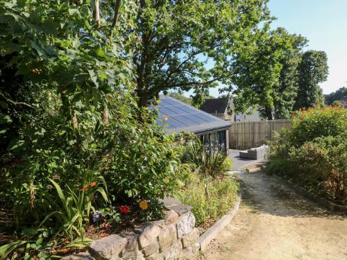 a garden with a stone wall and a house at Cornerstones Brython in Tenby