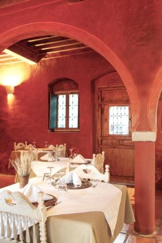 a dining room with white tables and red walls at Hotel Dar Dhiafa in Houmt Souk