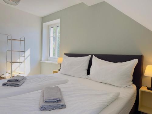 a bedroom with a white bed with towels on it at Urlaubsnest Millstatt in 5 Minuten am Millstätter See in Millstatt