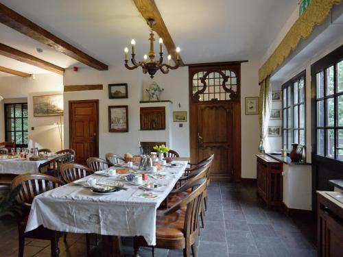 Un comedor con una mesa con sillas y una lámpara de araña. en Spacious Villa in Liège, en Spa